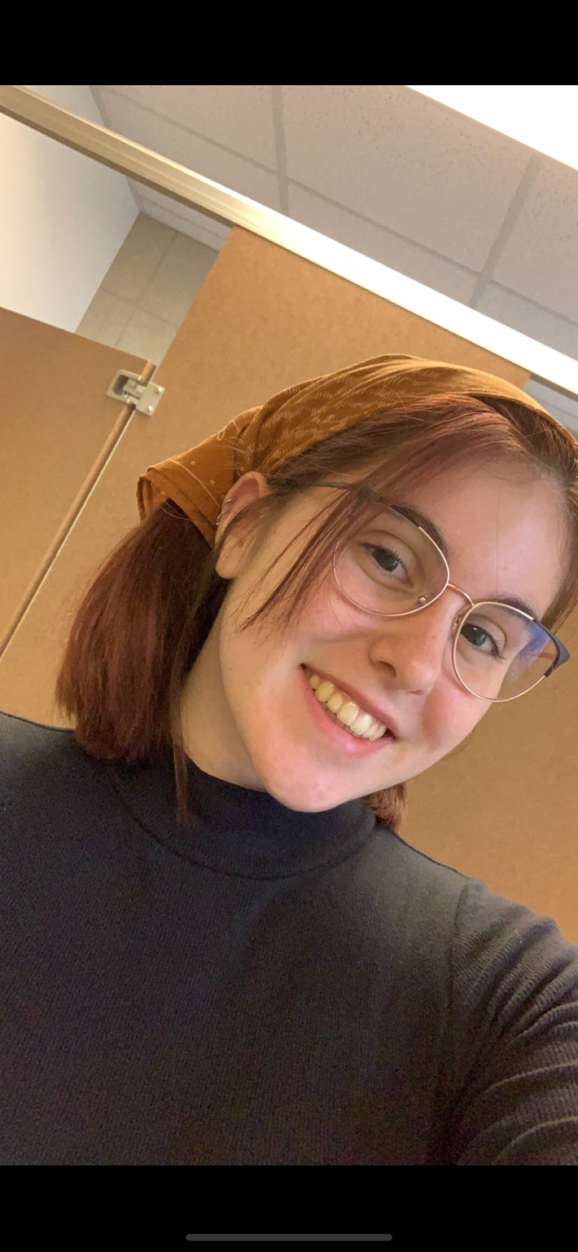 Chelsea Aiken smiling in a black, high neck sweater.